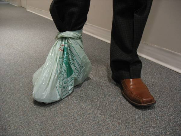 A person wearing grocery bag over shoe.