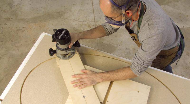 Man using a jigsaw and jig to cut a perfect circle in wood.