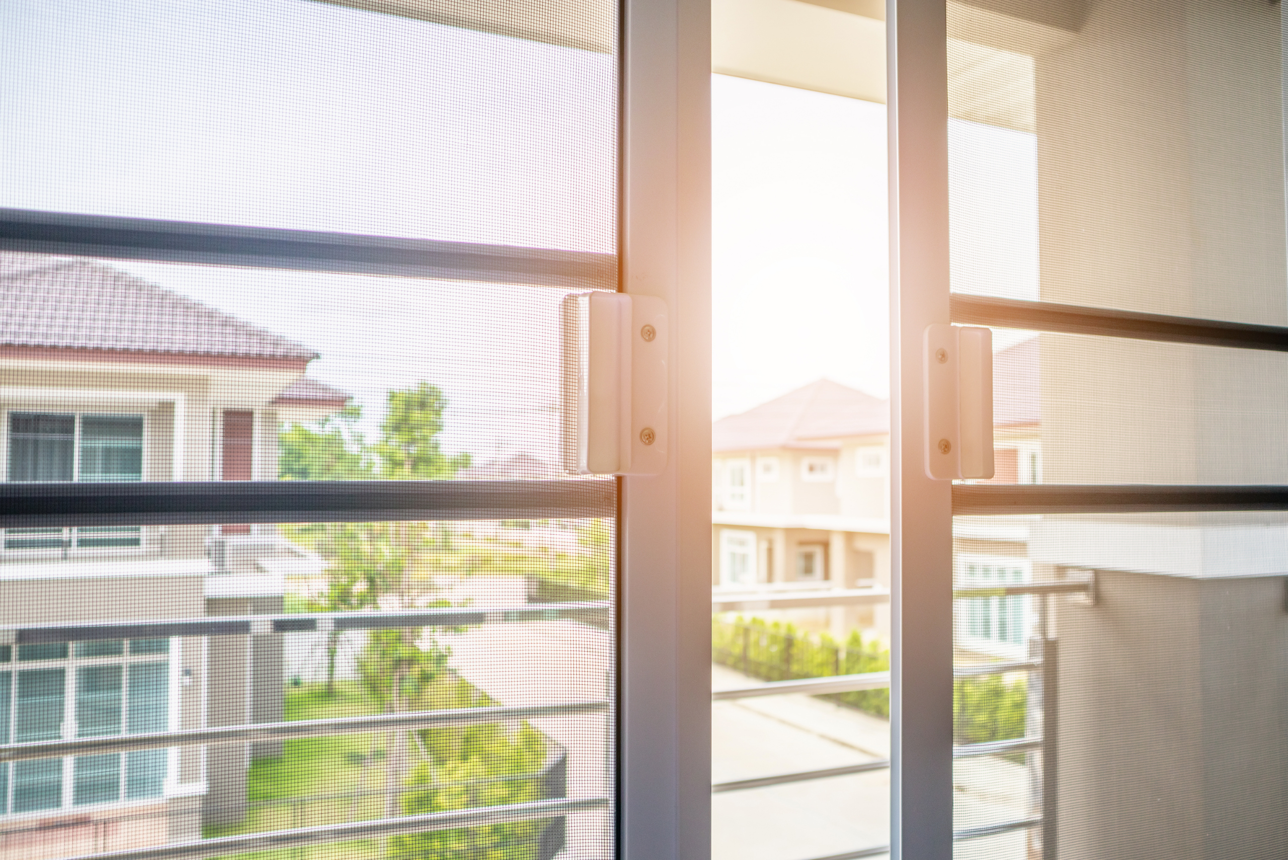 Double screen doors installed flanked by sunshine.