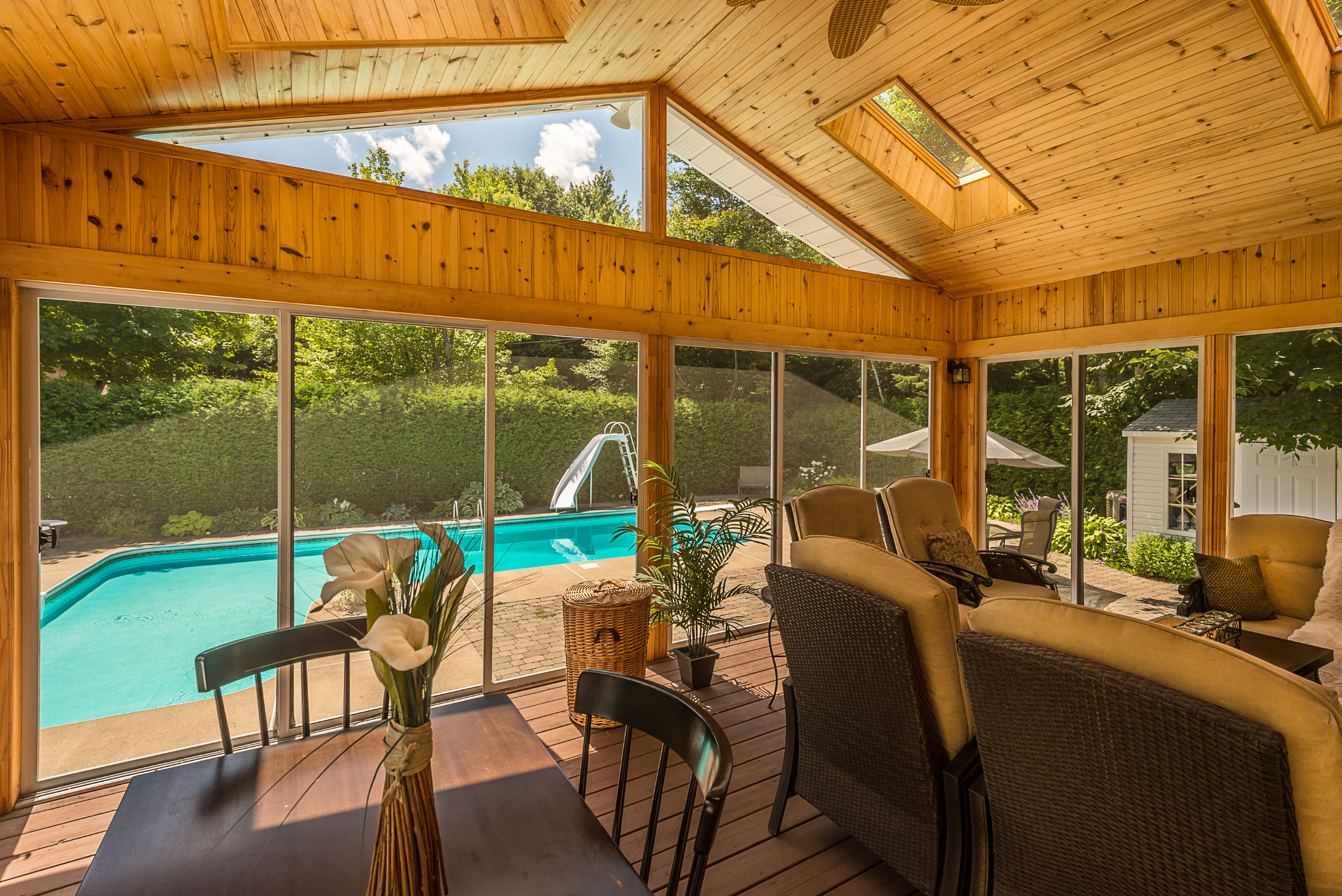 Wooden screened-in porch flanked by a backyard pool.