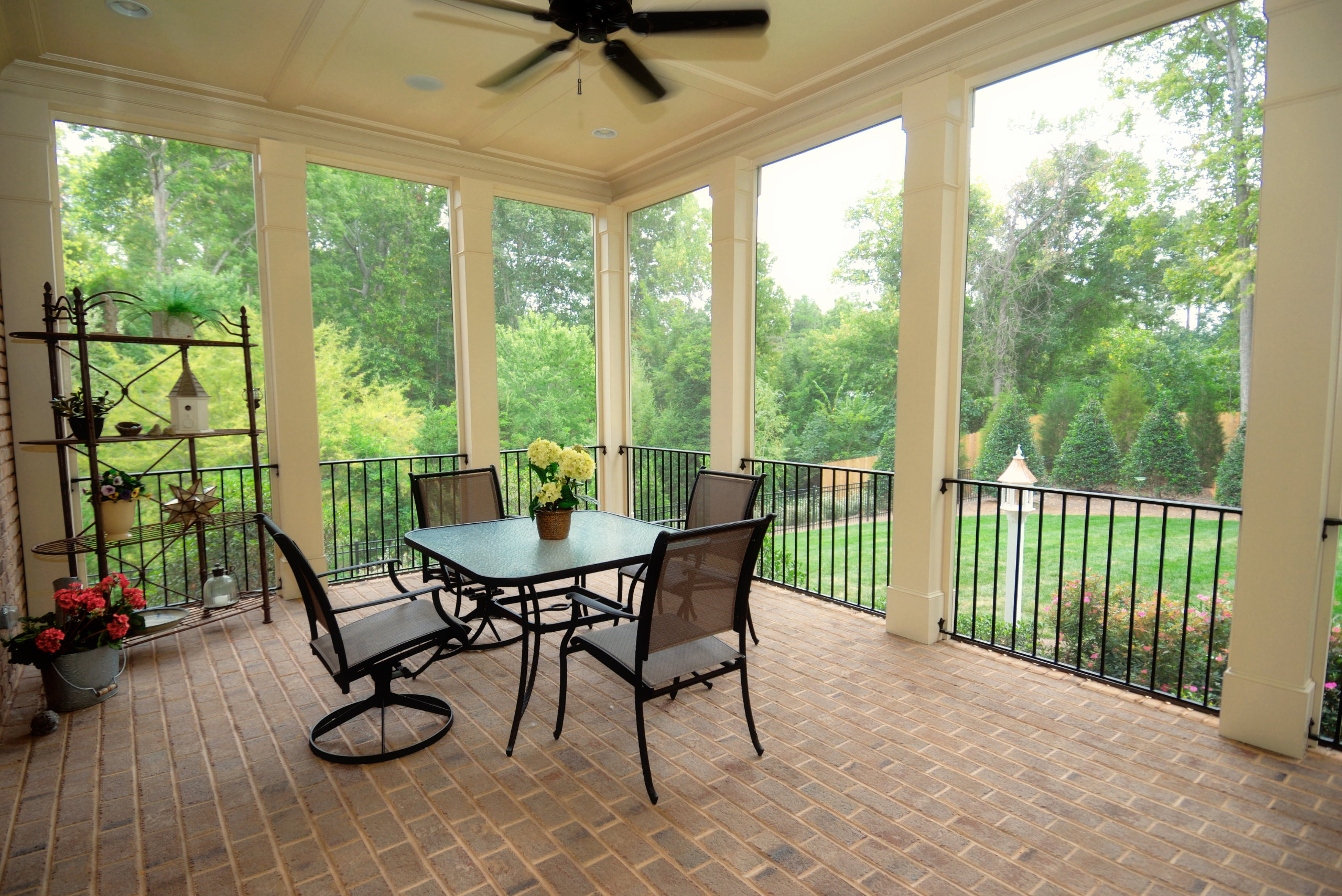 A screened-in porch with black railings.