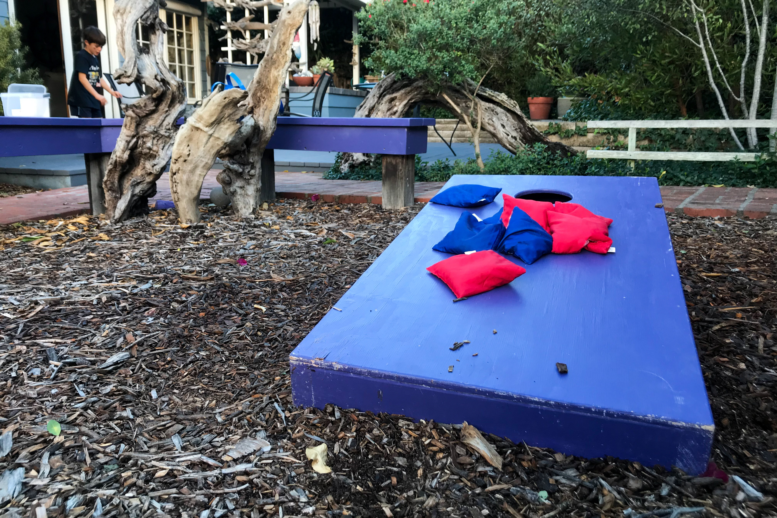 Blue corn hole board with bean bags on top.