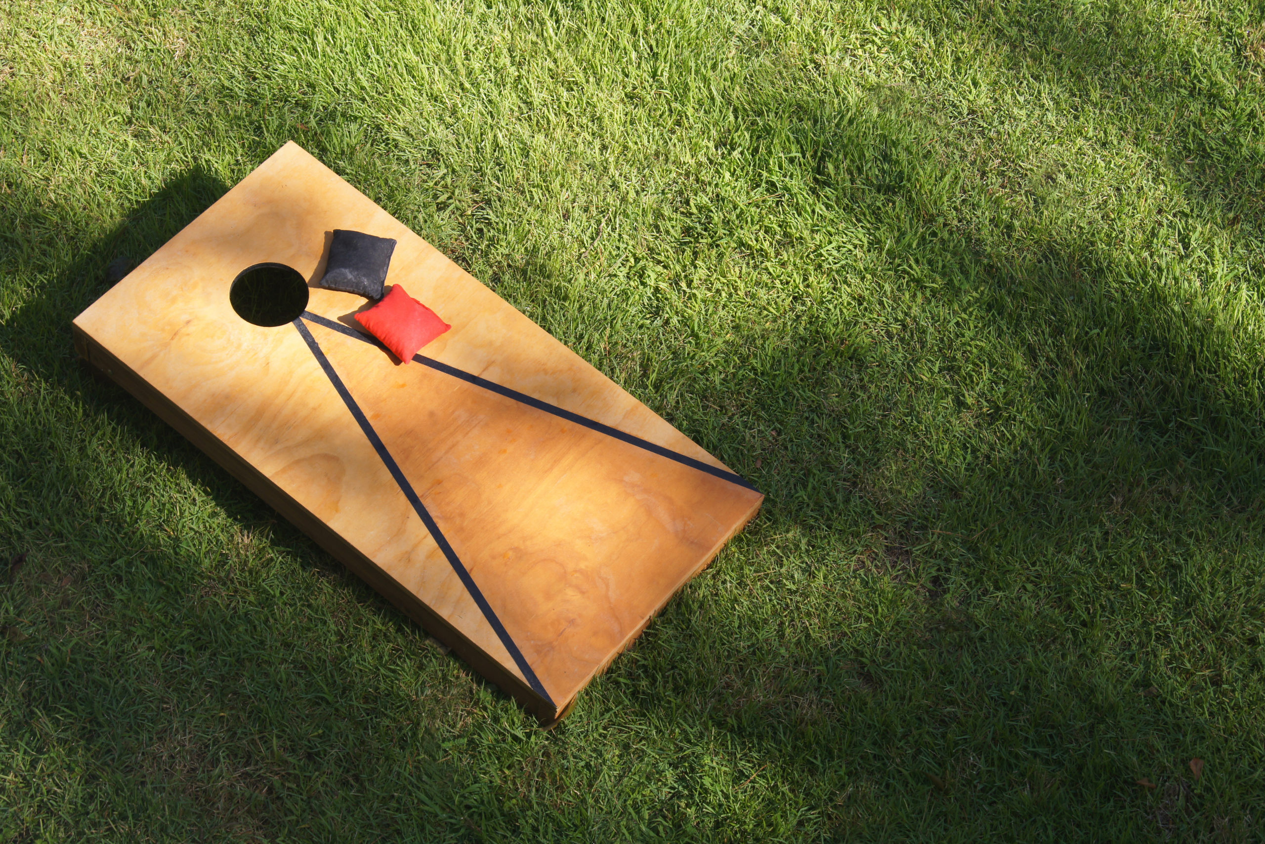 Classic corn hole boards with black lines and wood finish.