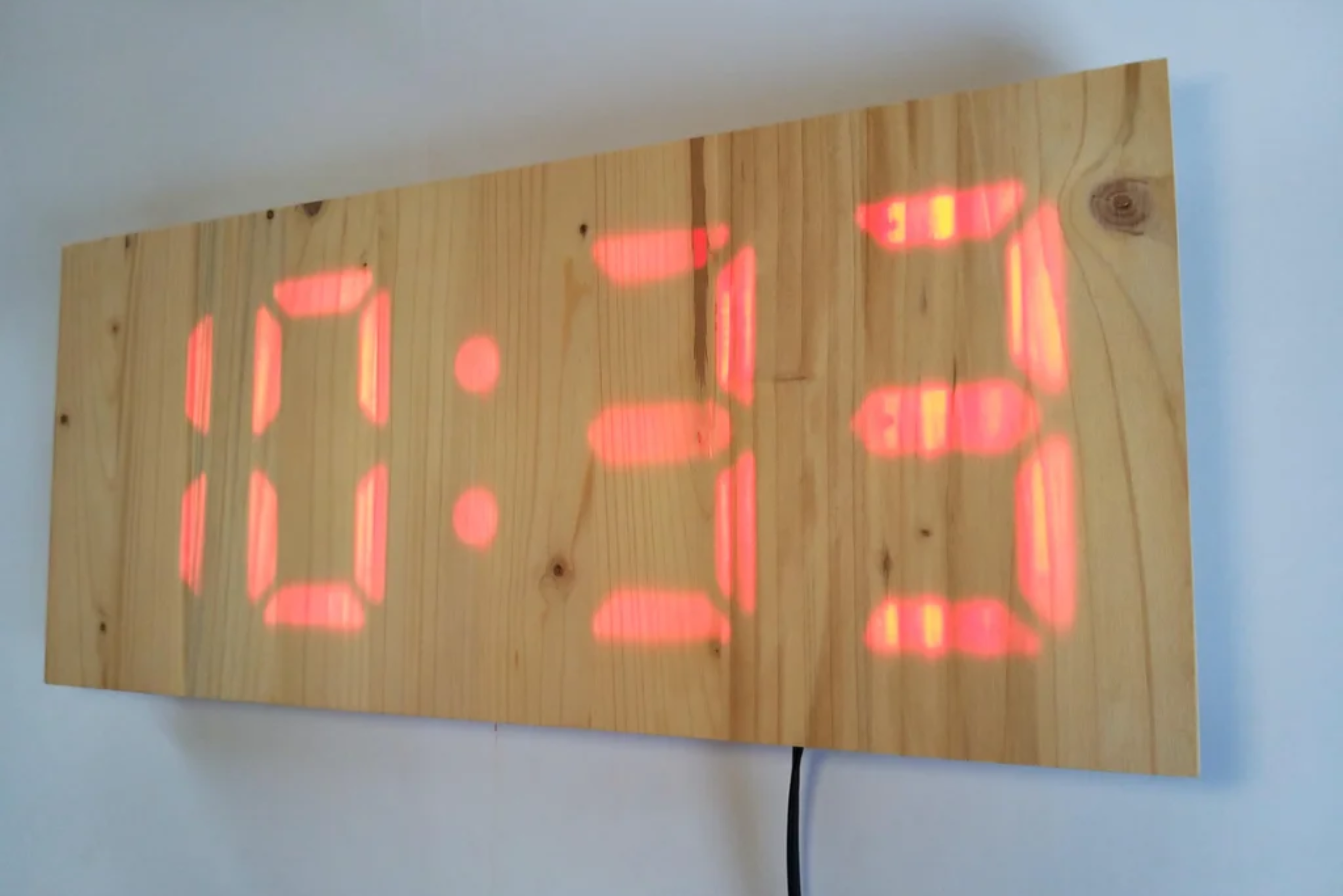 A digital clock displaying on a wooden board.