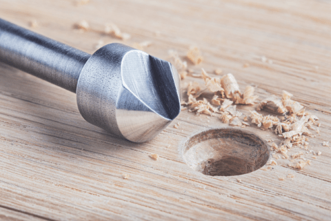 A countersink tool with wood and countersunk hole.