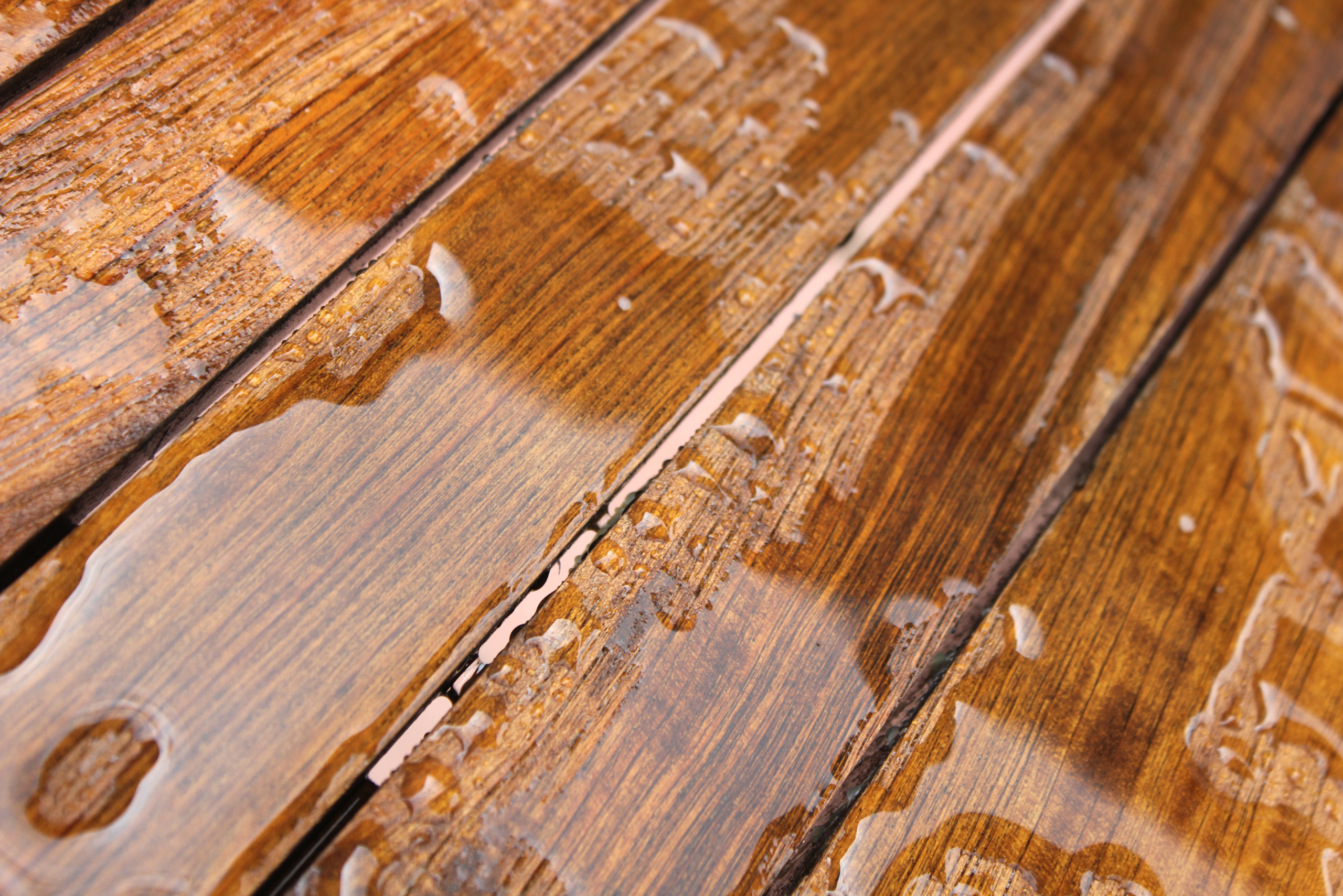 Water pooling on top of sealed wooden deck.