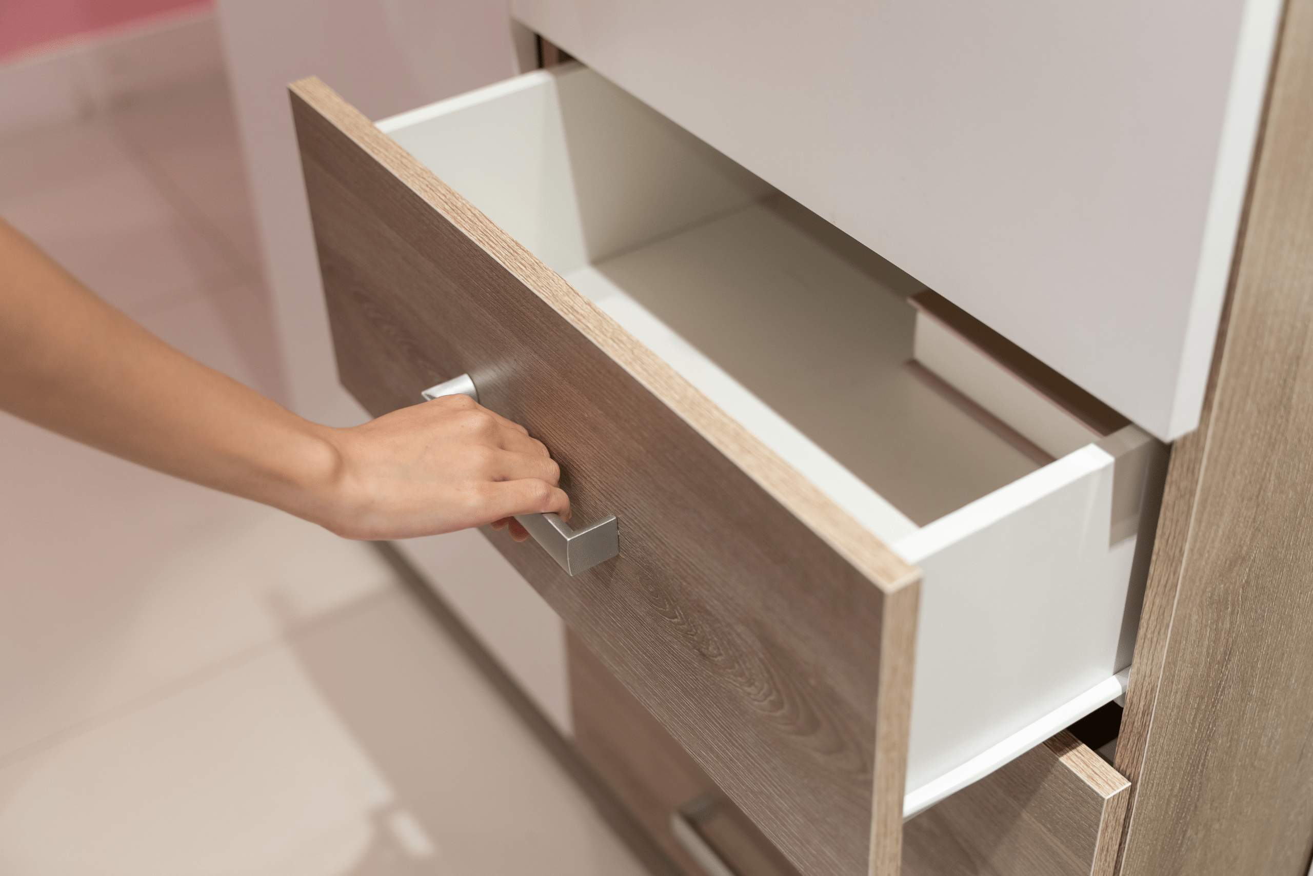 A person pulling open a wooden drawer.
