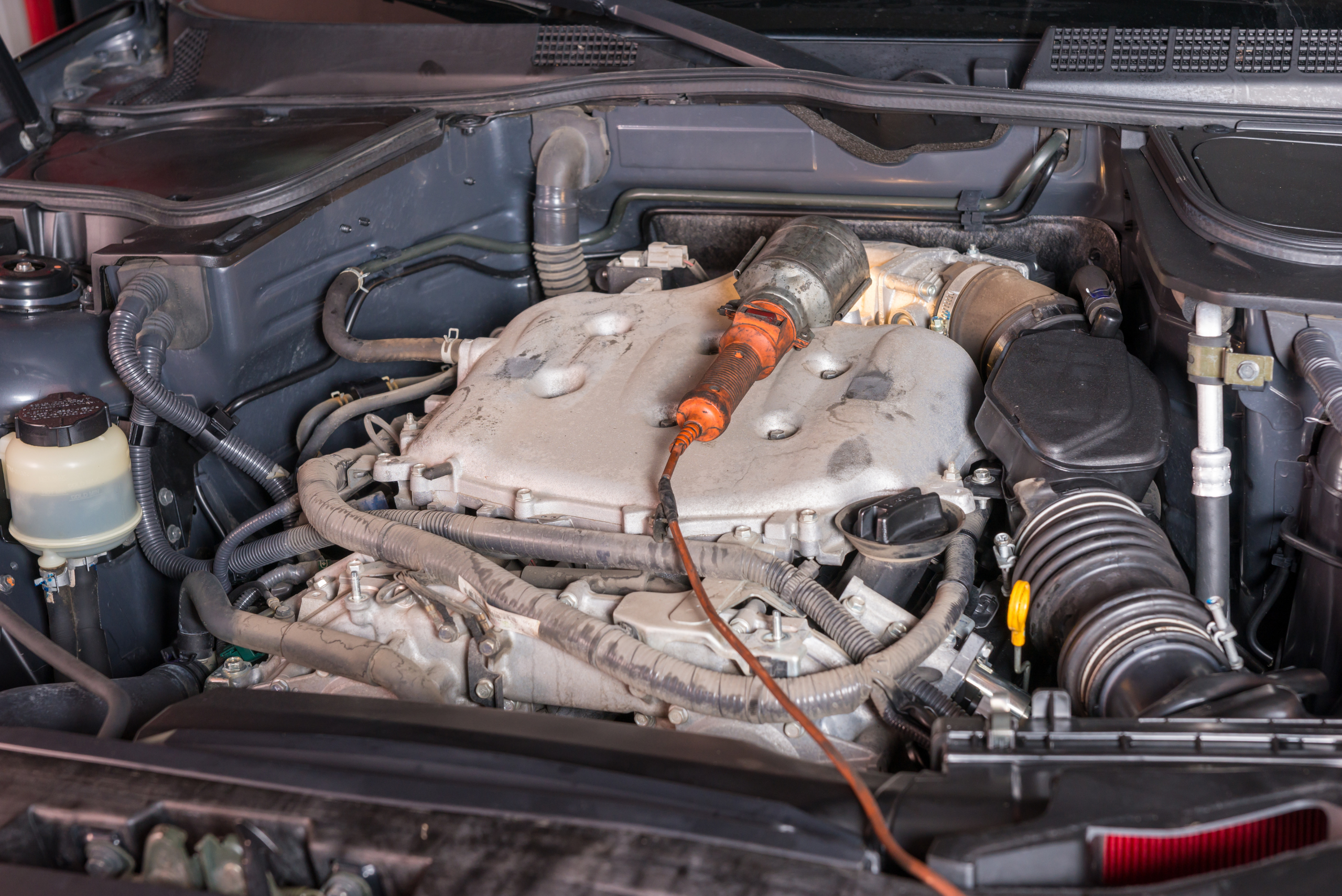 A portable task light on top of a car engine.