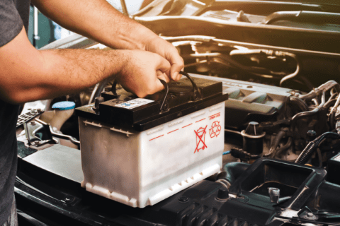 Person removing car battery.