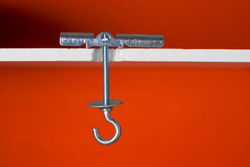 A toggle bolt from side view, showing drywall and back where the toggle bolt mounts.