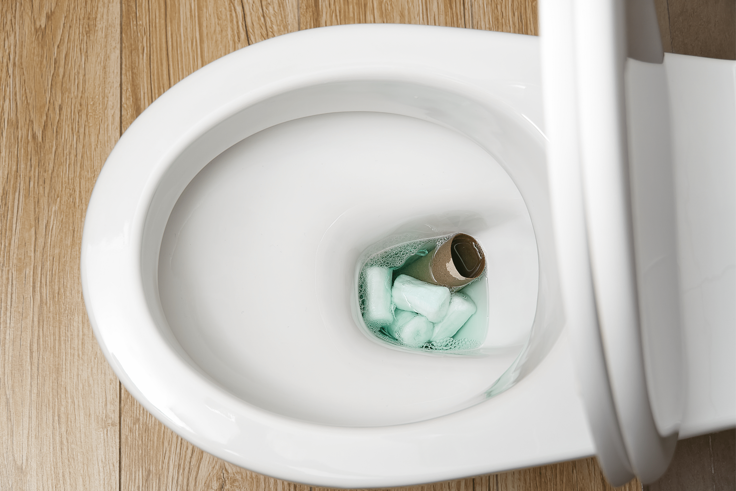 A toilet clogged with toilet paper roll.