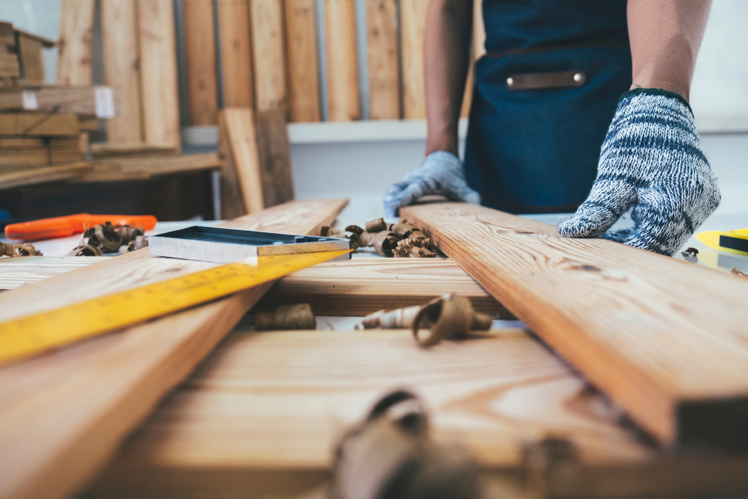 A person handling wood in workshop.