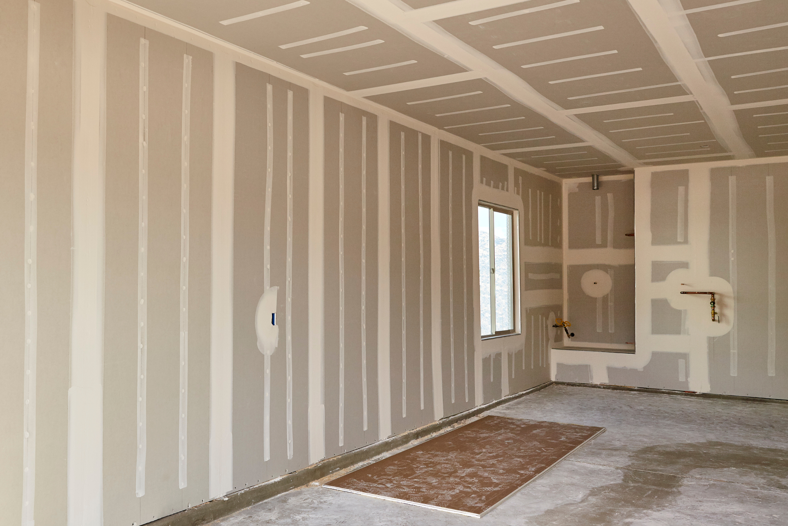 A finished room with hung drywall and smooth mudding.