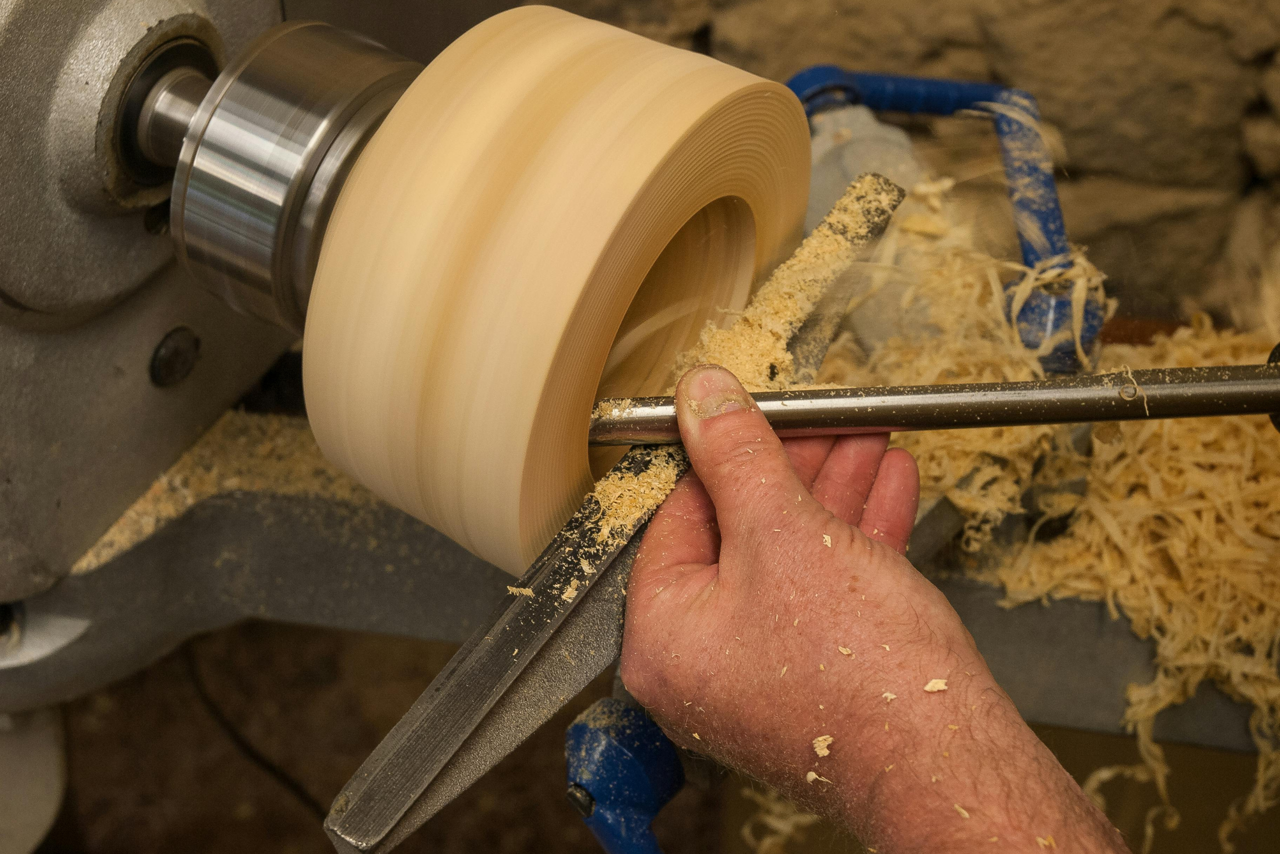 A person using a lathe for woodturning a piece of wood.