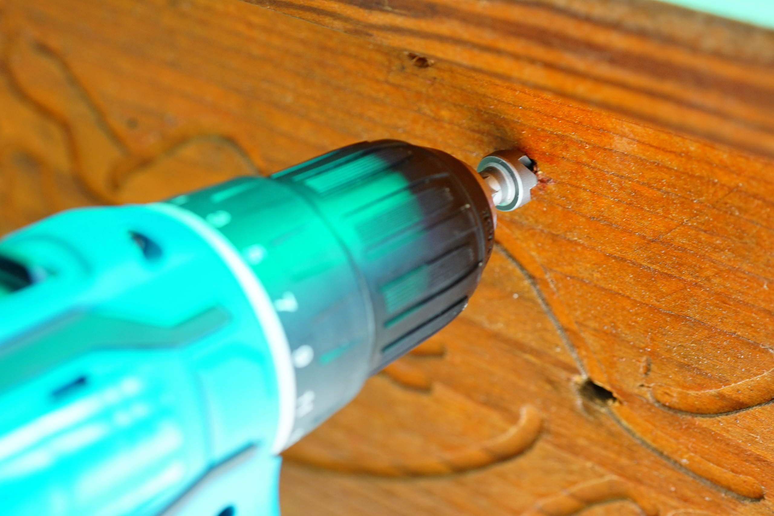 Using drill with countersink bit to create a cavity in wood for countersunk screw.