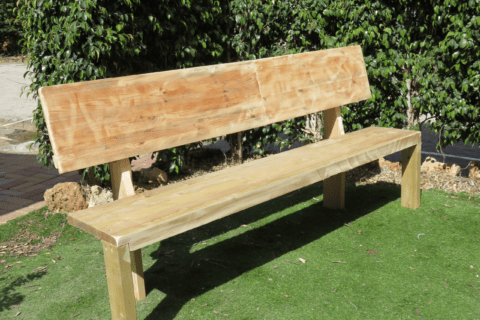 A wooden bench in backyard.
