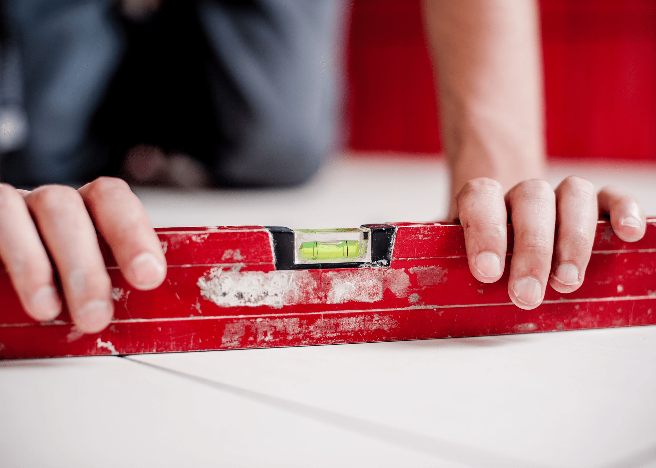 close up of red level and man holding on table