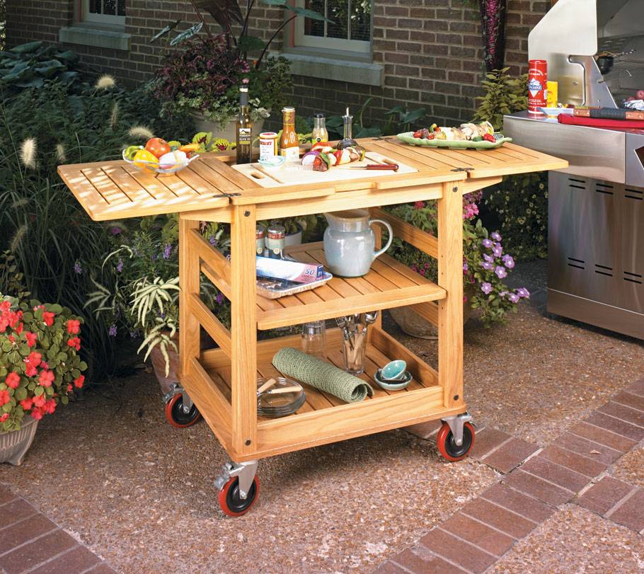 A wooden patio serving cart loaded with supplies.