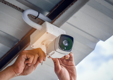 hands installing security camera close up