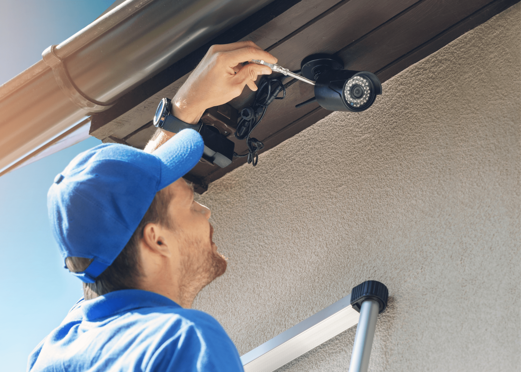 professional man installing a security camera to outside of house