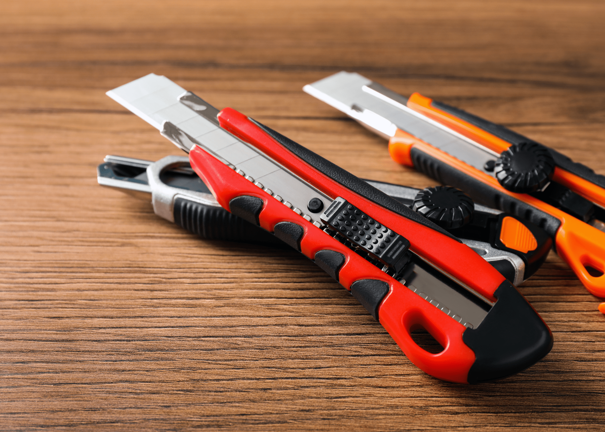 close up of utility knives on wood background