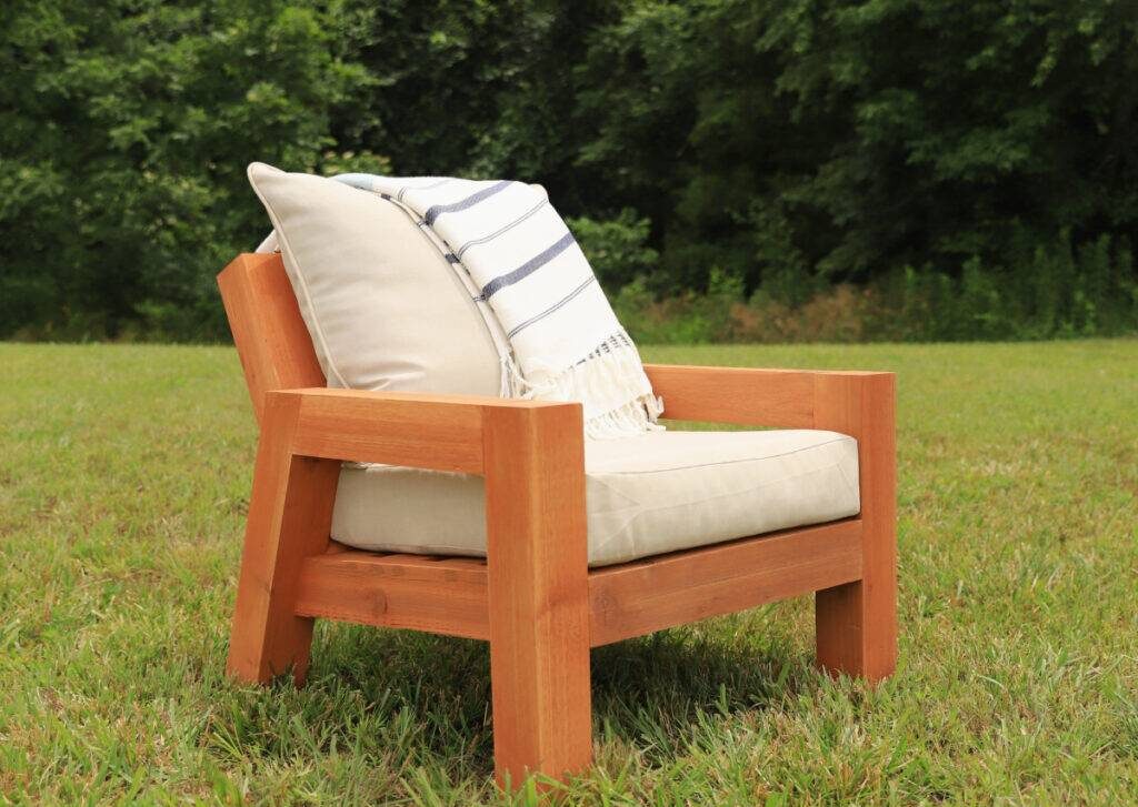 A wooden chunky patio chair with cushions.