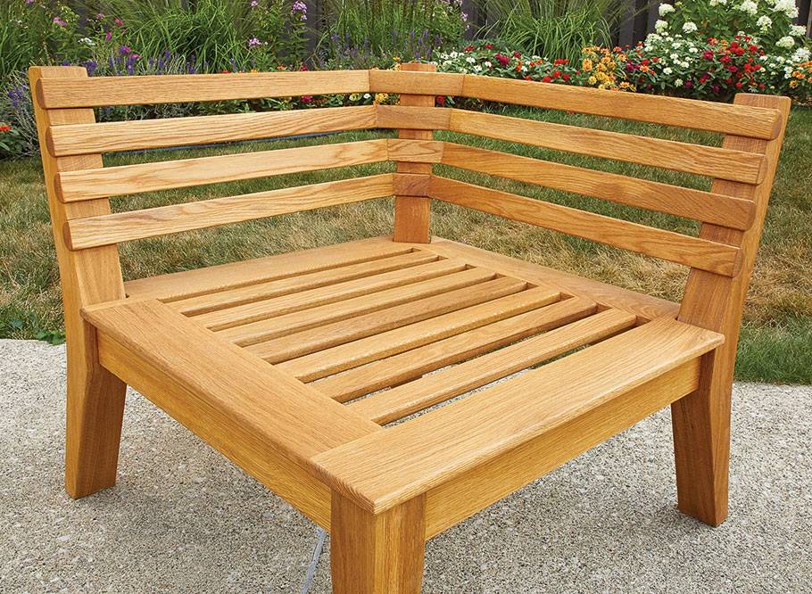 A corner patio chair made from wood.