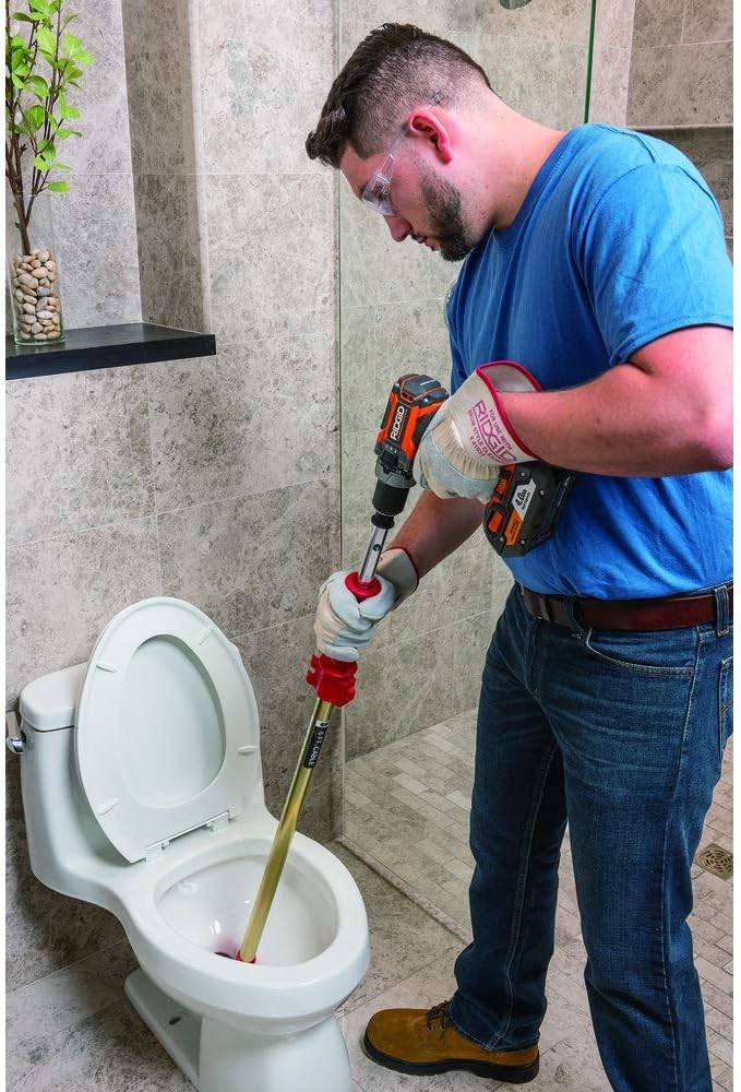 A person using power drill attachment for toilet snake to unclog toilet.