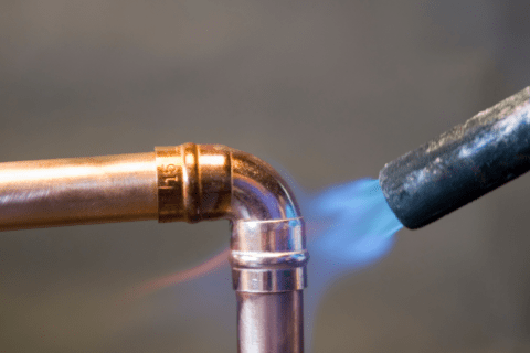 Torching a copper pipe for soldiering.