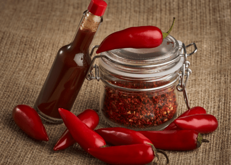 red chili peppers hot sauce and spices in jar