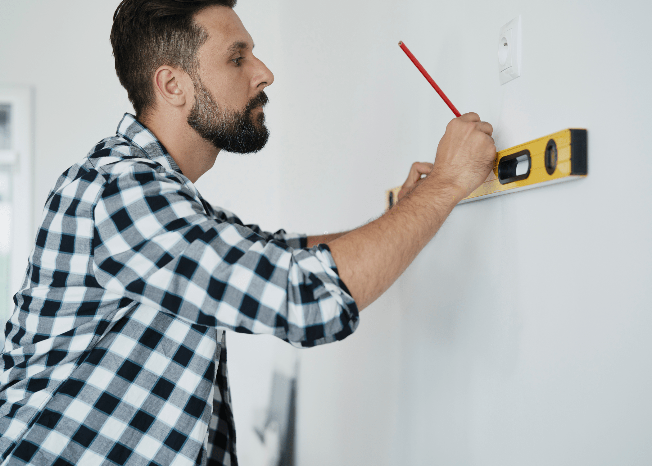 man using a level on the wall