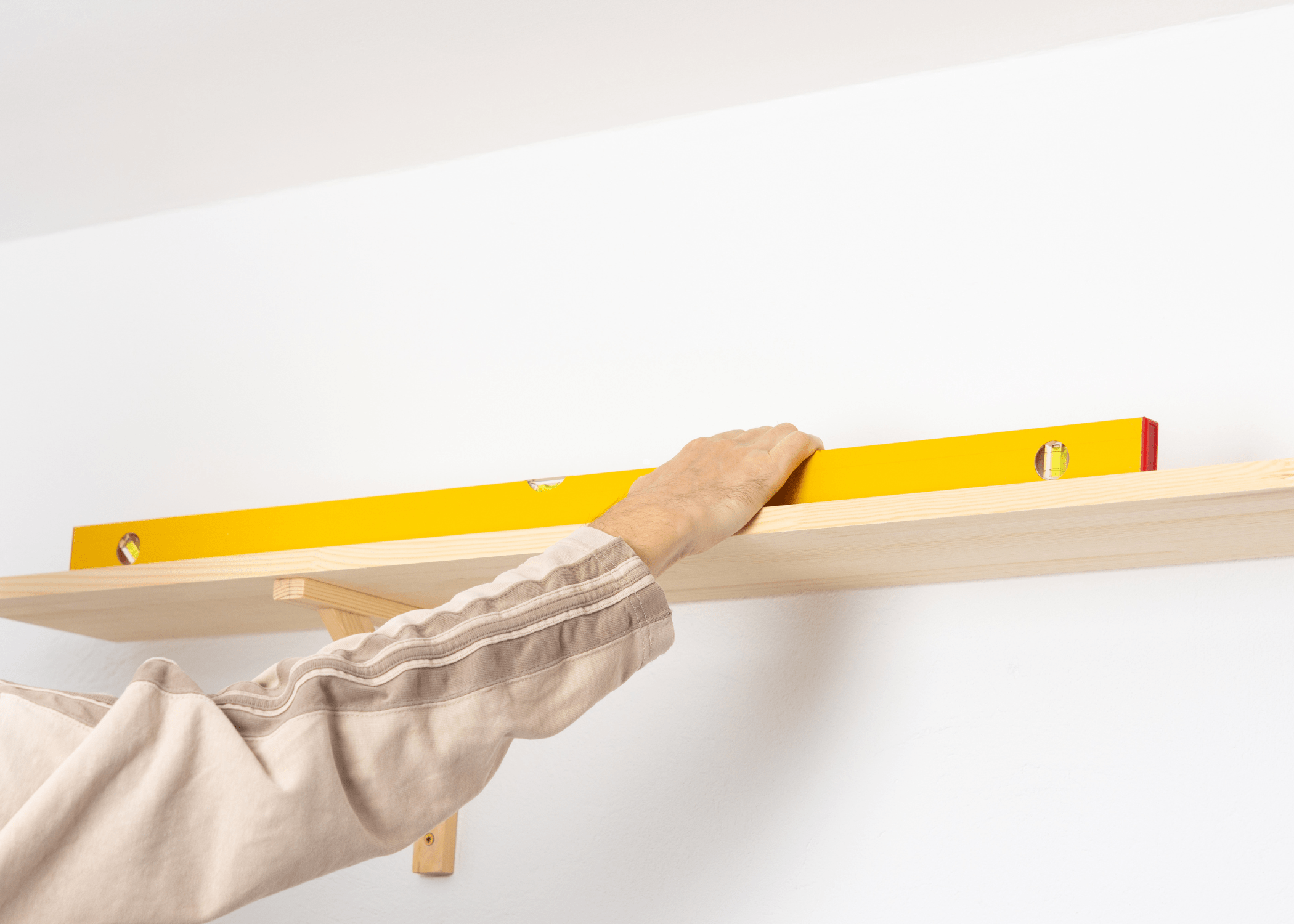 using a yellow level to hang a shelf