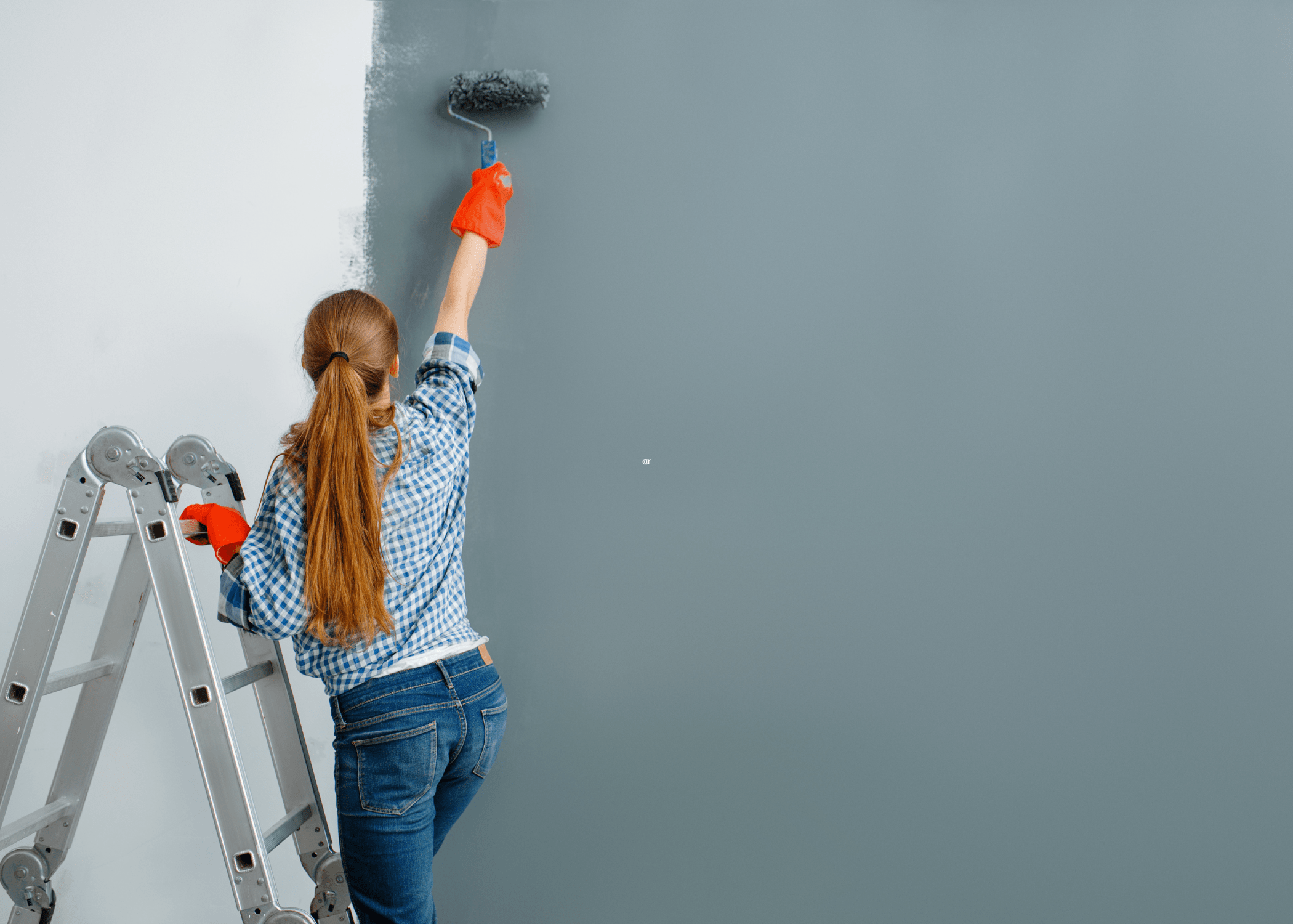 woman painting a wall with a roller