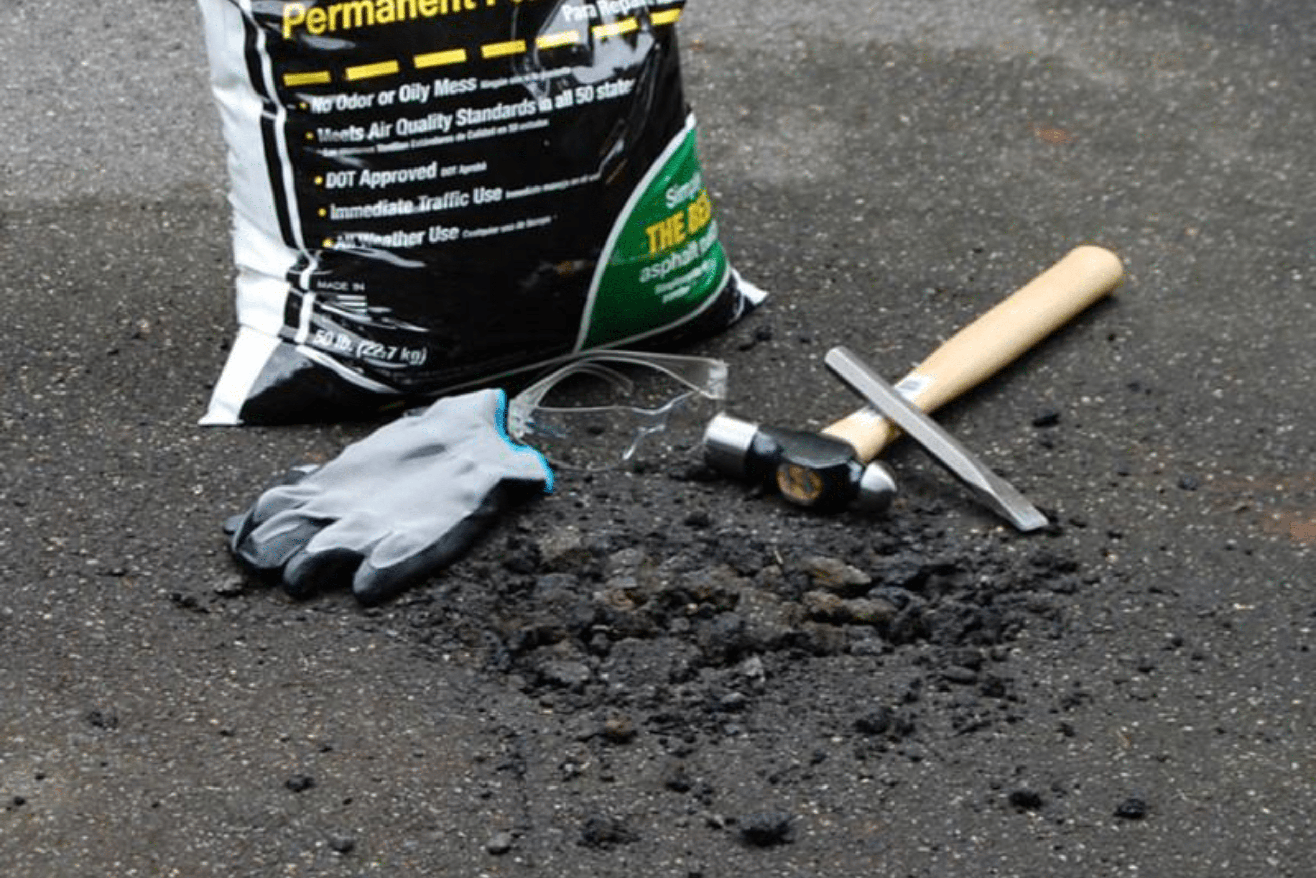 Tools and materials to repair asphalt driveway cracks.