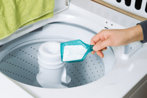 Adding washing detergent to washing machine.