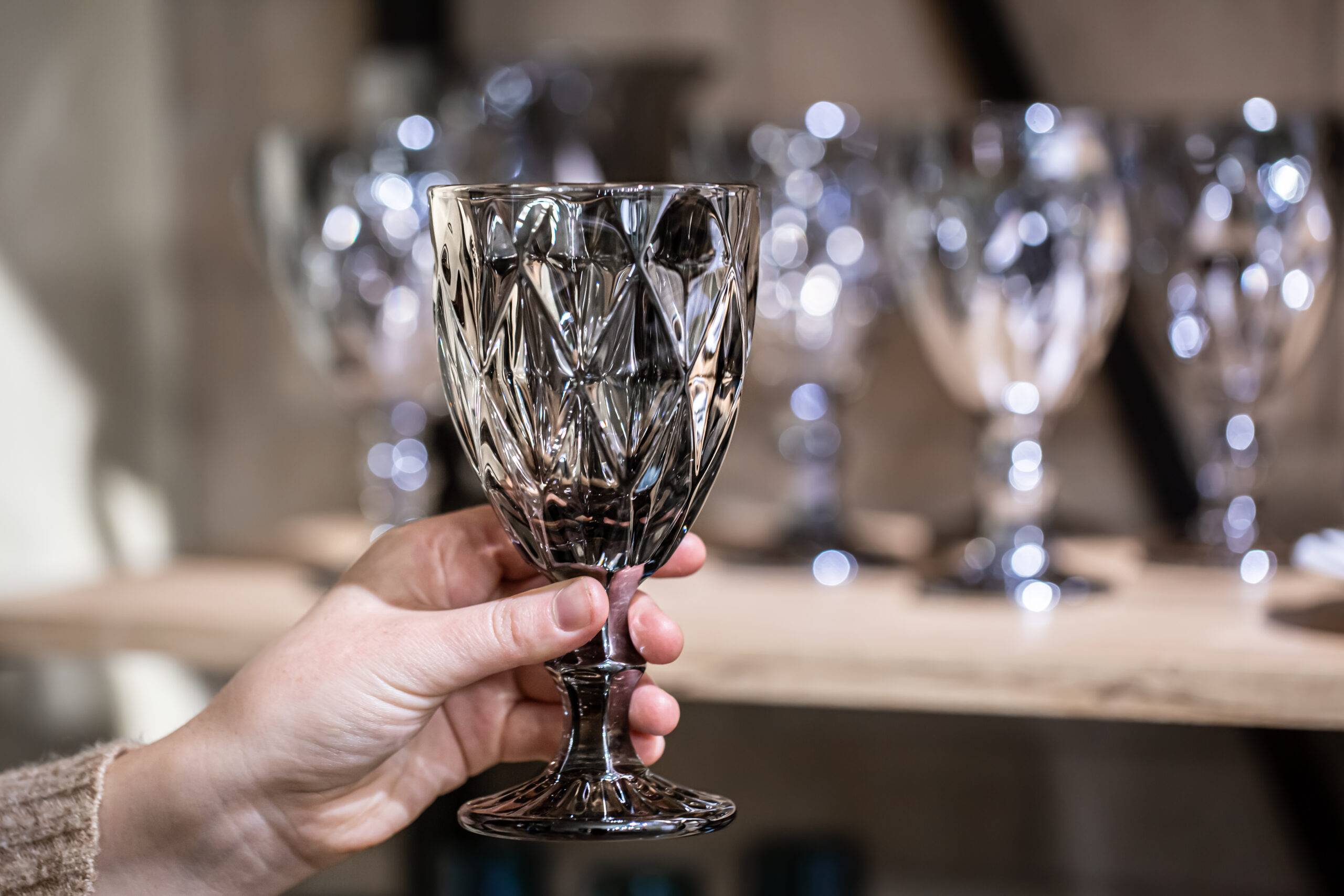 Close-up of a textured glass in female hands on a blurred background.