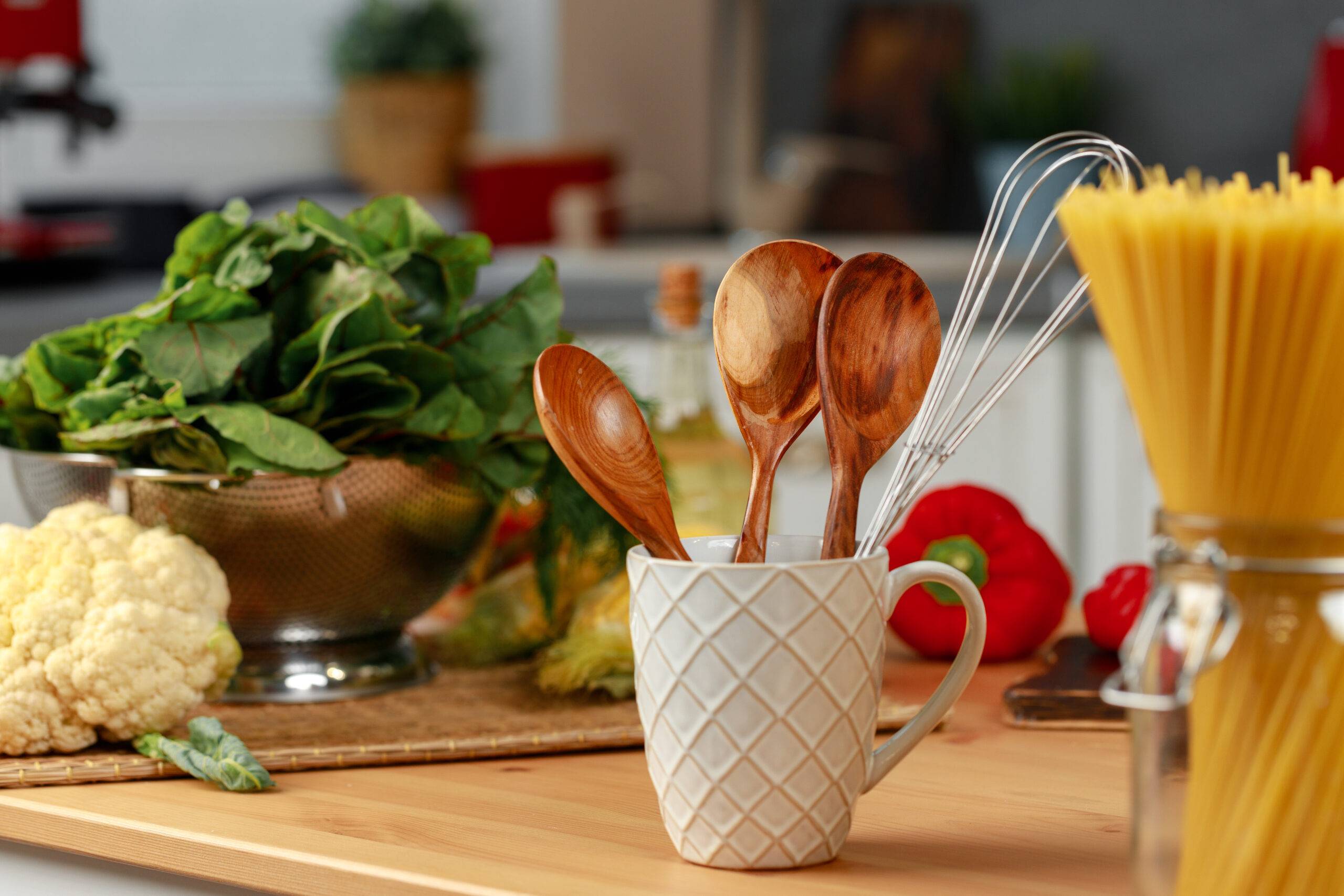 Wooden spoons in a cup on kitchen table close up