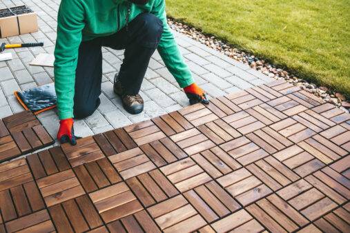 Skilled craftsman laying wood flooring on a terrace at home
