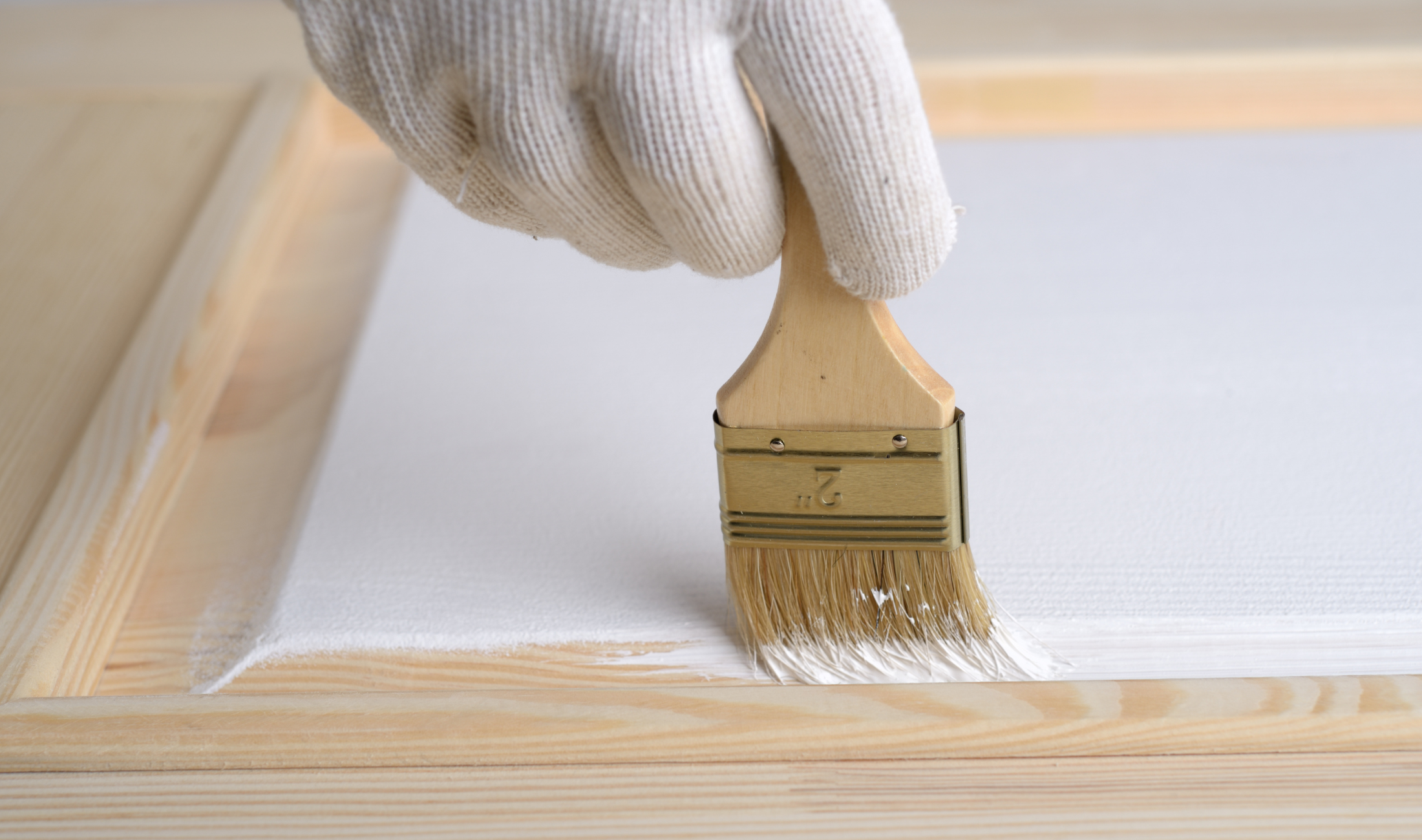 A close view of someone painting a door panel.