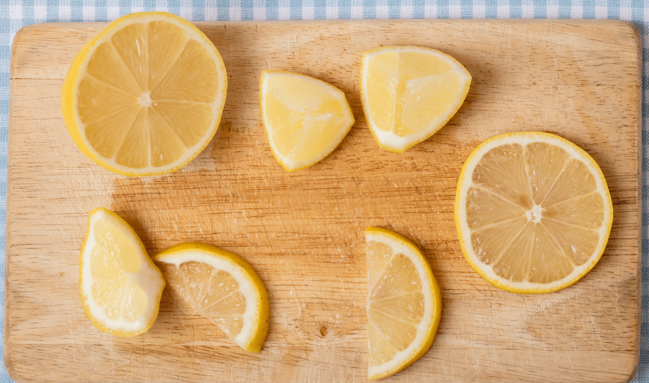 A cutting board with cut up lemons on it.