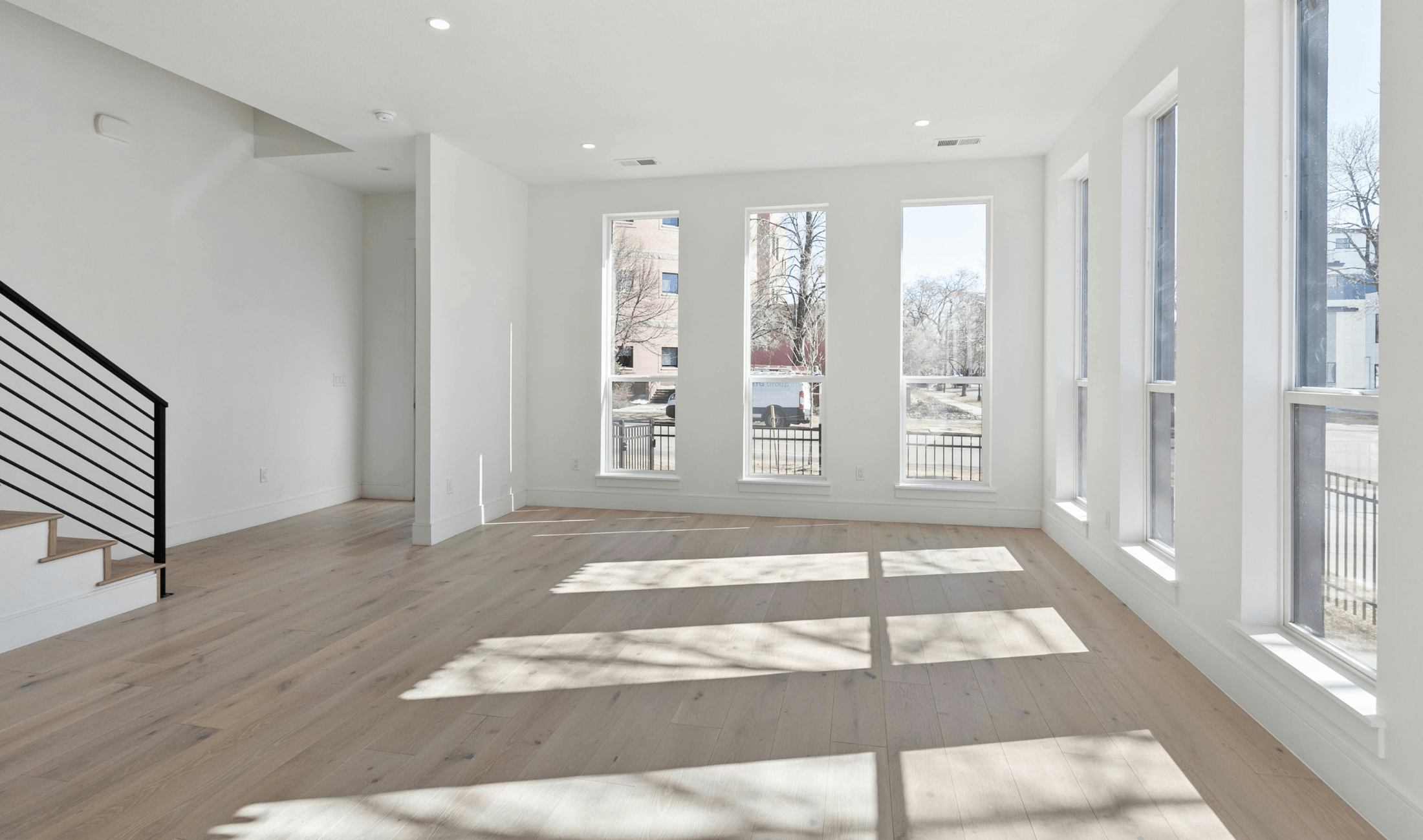 An empty, newly renovated room with vinyl floors.