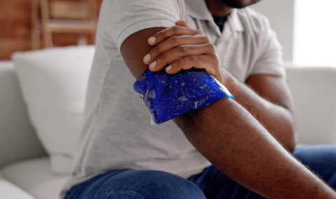 A man holding an ice pack on his arm.
