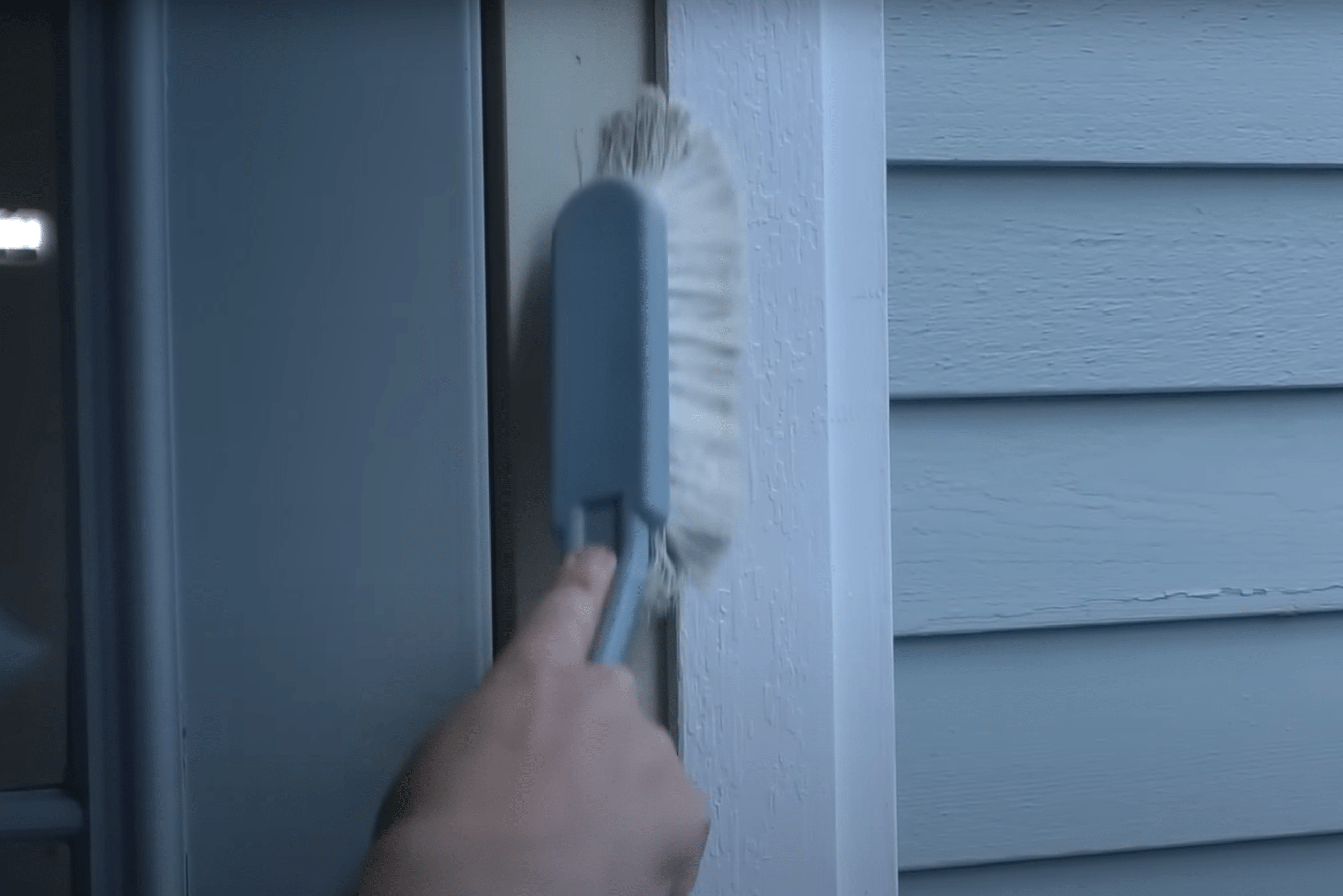 Using brush to clean up door frame.