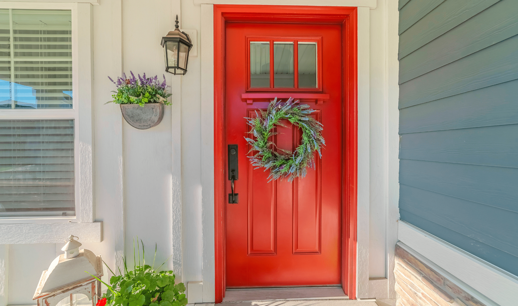 A bright red front with a summer wreath on it.