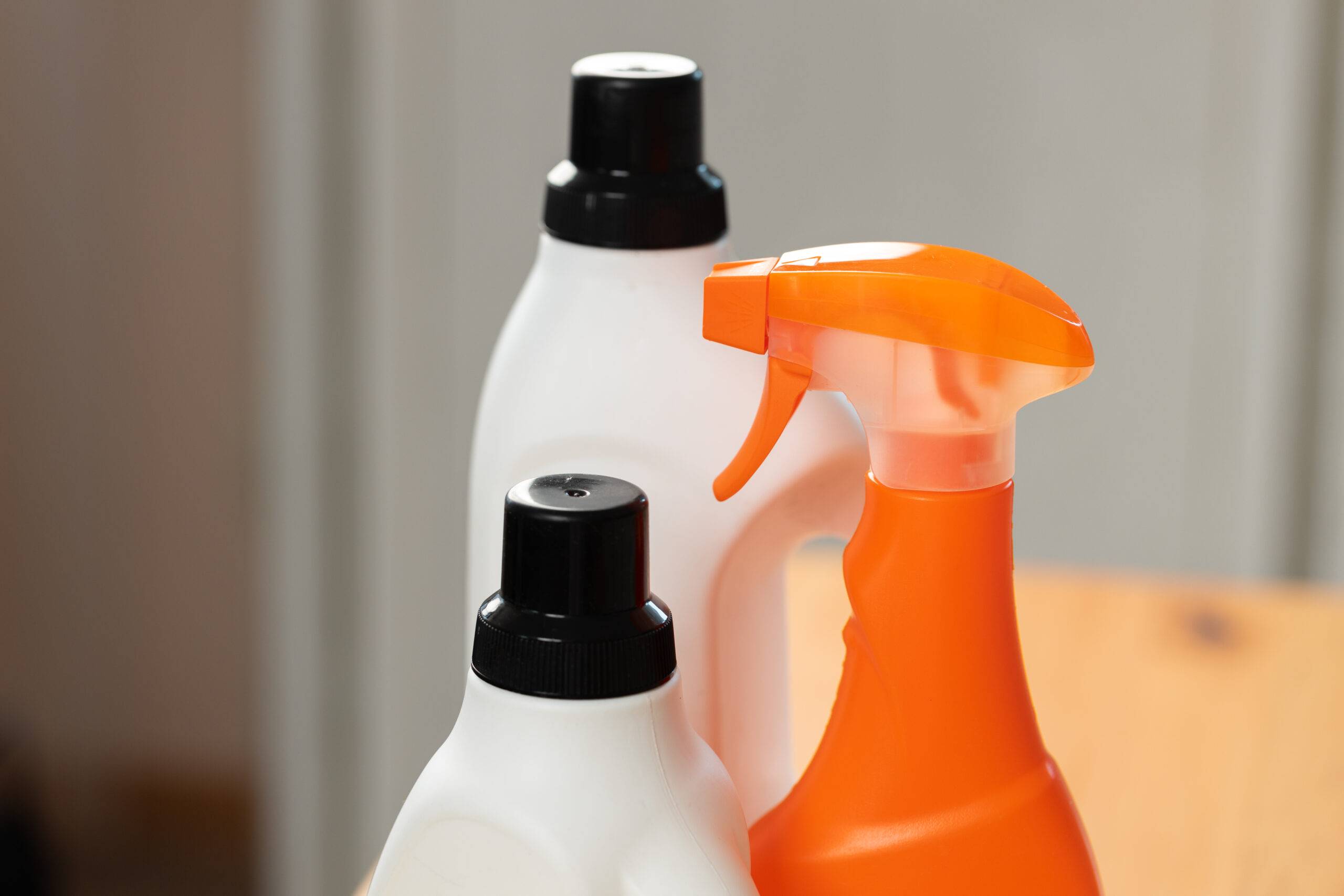 Cleaning detergents and tools on a kitchen counter close up