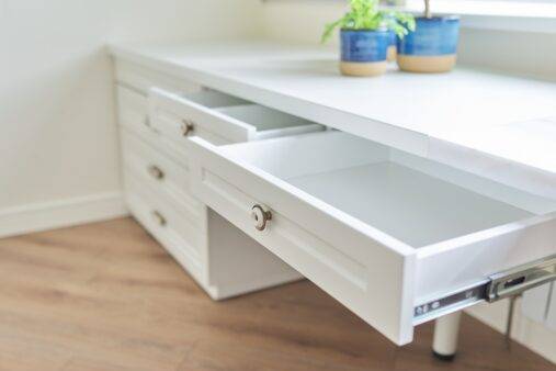 Furniture, white table, open top secretaire drawer. Close up details of furniture