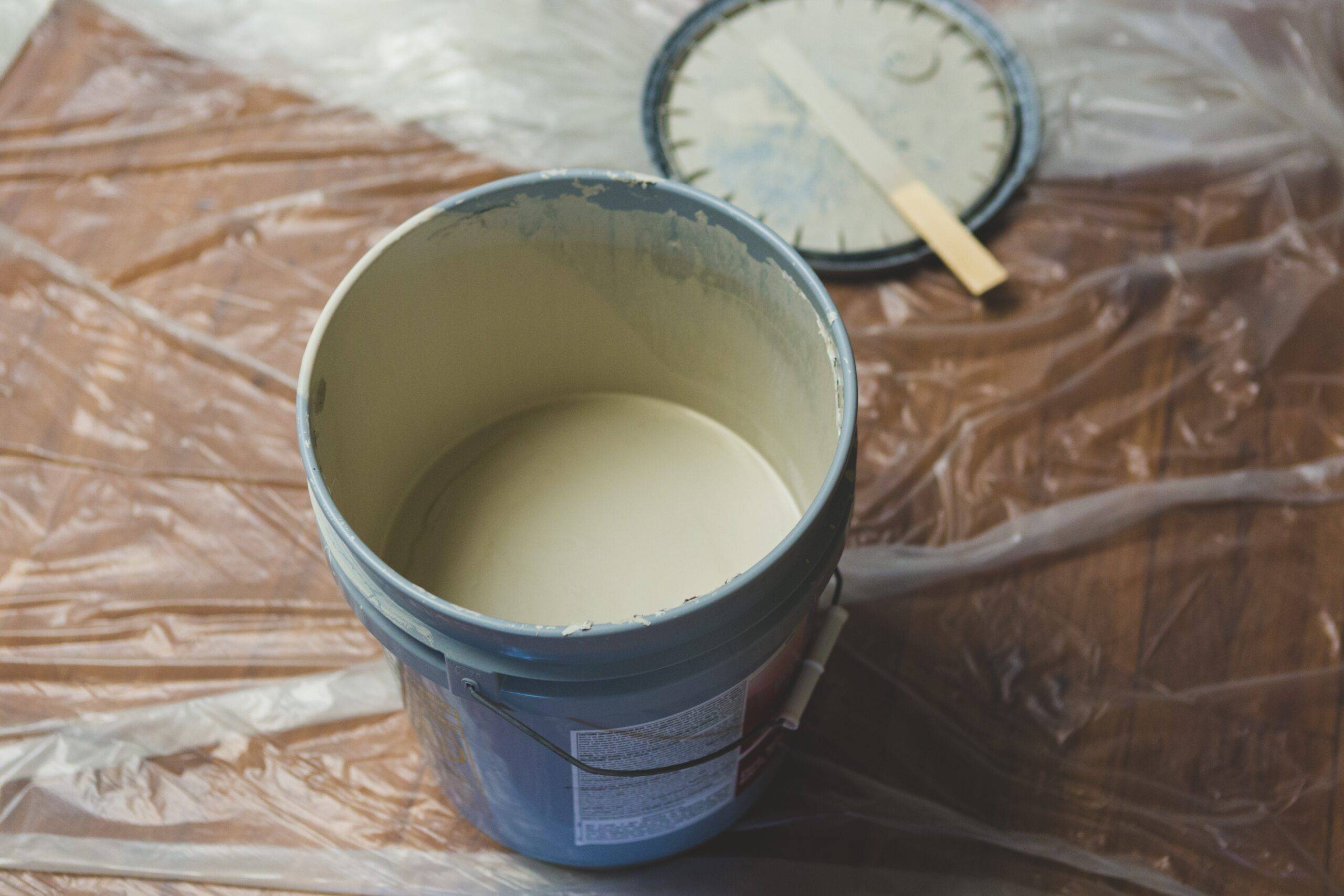 An open, large bucket of off-white paint.