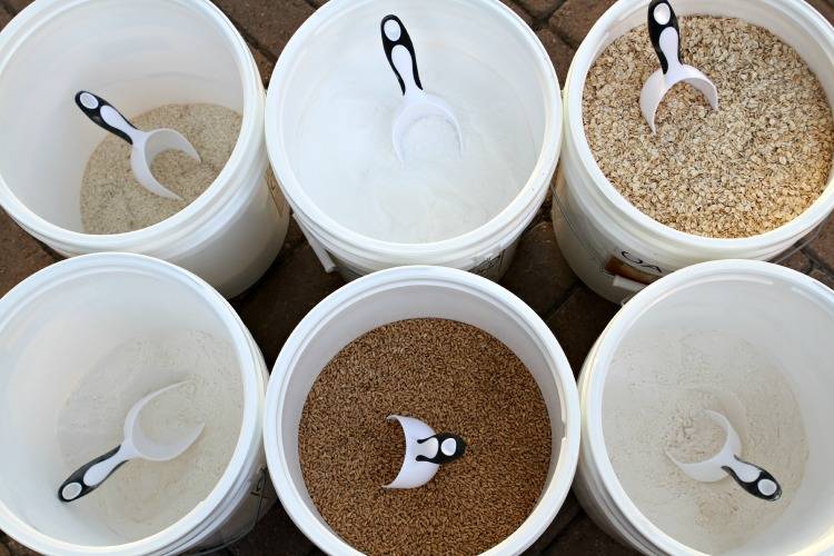 An above shot of 6 5-gallon buckets with various pantry staples in them.