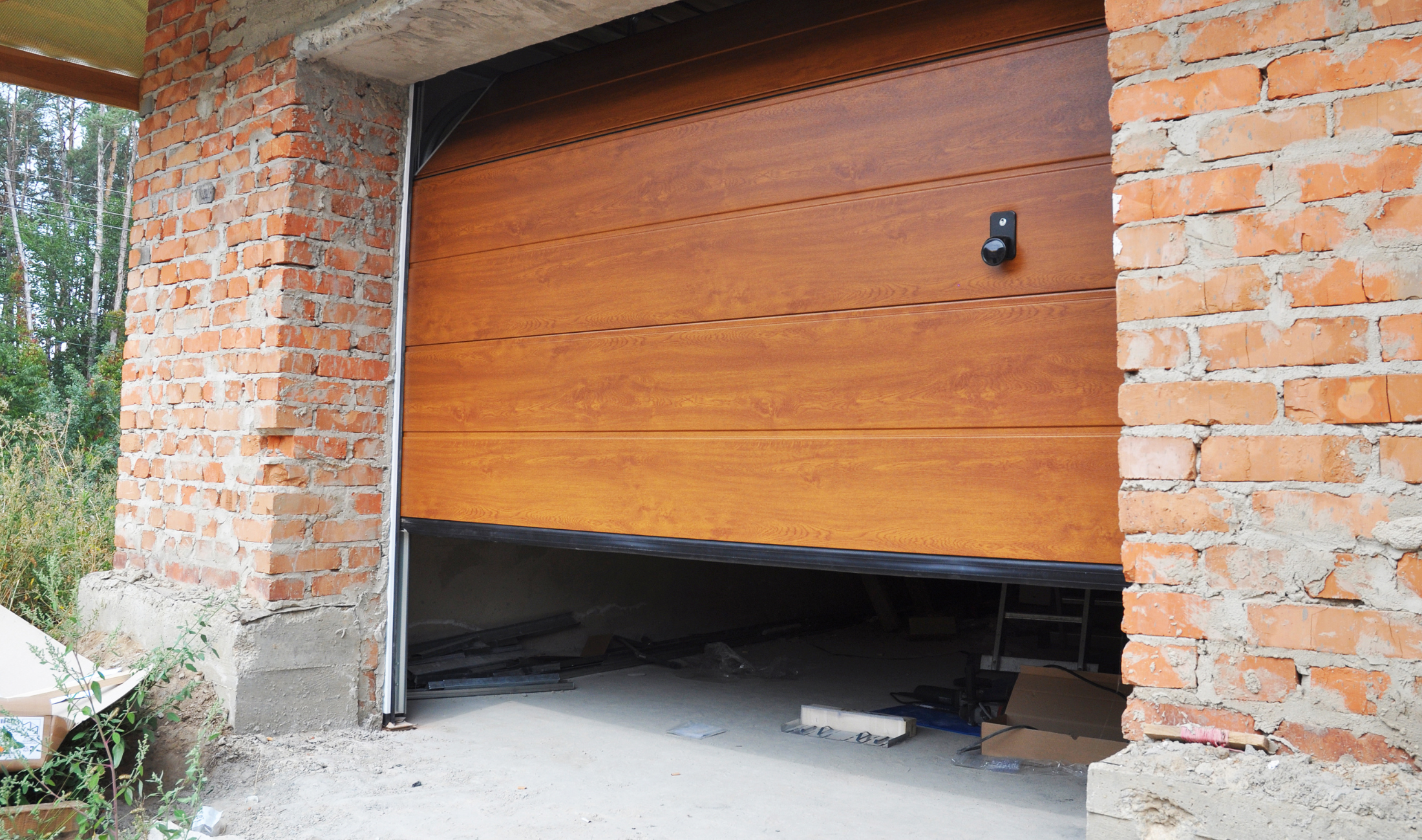 A garage door made of wood that's open a quarter of the way.