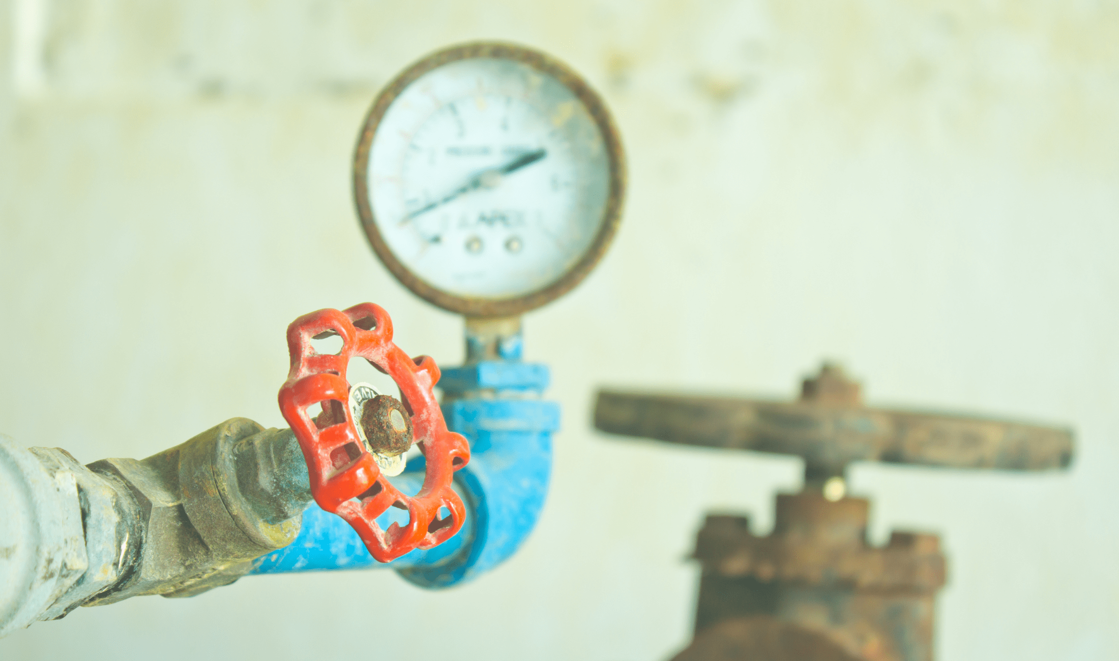 A bright red water shutoff valve on a pipe.